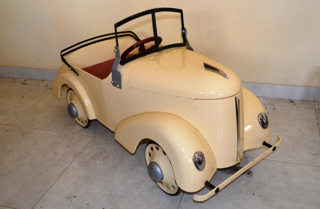 Vehículo de pedal, de color Beige para los niños, en lámina de la época del cincuenta, actualmente restaurado.