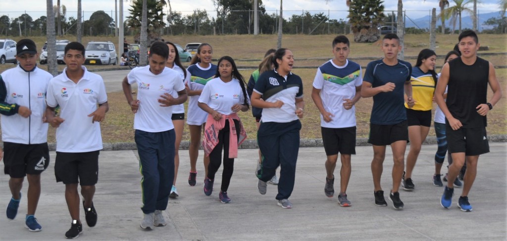 Los jóvenes deportistas iniciando los entrenos con estiramientos y calentamiento.
