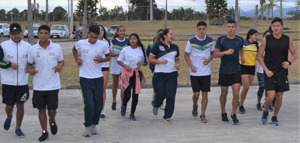 Los jóvenes deportistas iniciando los entrenos con estiramientos y calentamiento.